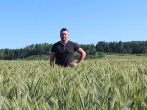 Viljelijä Henrik Hellgren ja syysruisvehnä SU Toppus